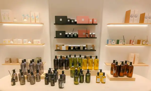 Флаконы и коробки косметики на освещённых полках
